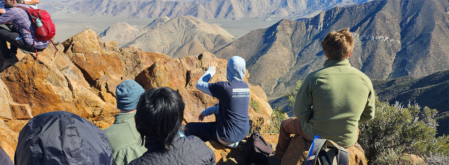Students hike - climb a rocky viewpoint area